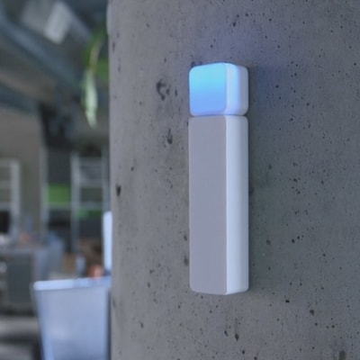 Luxafor Bluetooth Busylight, hvitt, på veggen lyser blått