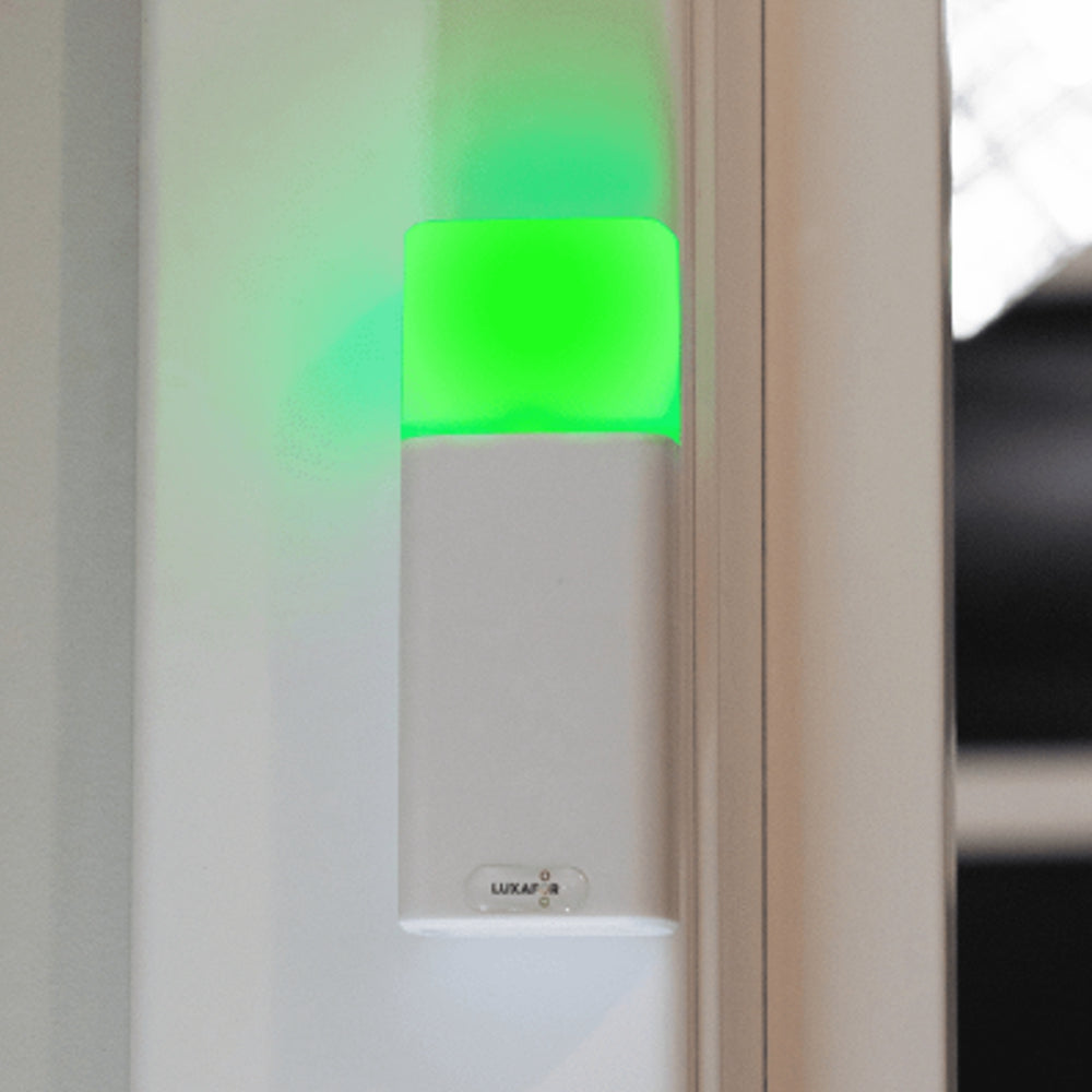 Luxafor Bluetooth Pro Busylight hvitt lyser grønt på vegg ved møtelokale