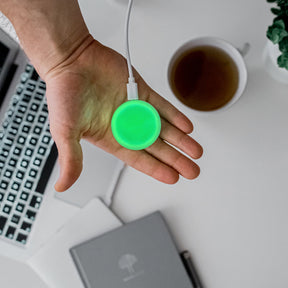 Luxafor Mute Button Busylight hvitt lyser grønt på hånd